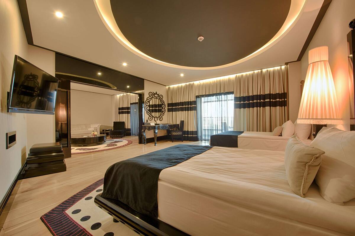 Una habitación de hotel moderna con una cama grande, un escritorio y una zona de estar.