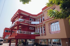 Un hotel de varios pisos con balcones y un patio central.