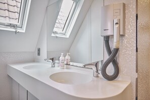 A modern bathroom with two sinks, a mirror, and a Valera air purifier. - The Classic by 2GO4 Grand Place (Brussels)