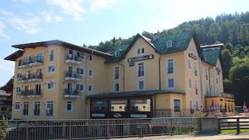 Un hotel de varios pisos con balcones, una cafetería y un restaurante.
