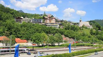 A hotel with multiple buildings, a train station, and a mountain backdrop.
