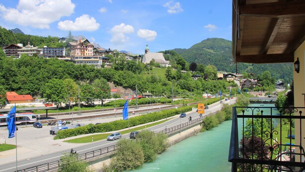 Une vue pittoresque d’une ville avec une rivière, des bâtiments et une montagne en arrière-plan.
