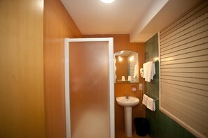 A bathroom with a white sink, a mirror, and a towel rack. - Pensión San Roque (Lugo)