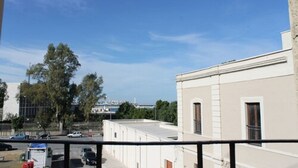 Un edificio con techo plano, balcón y cielo despejado.