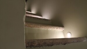 Una escalera con escalones de madera y techo blanco.