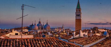 A cityscape with historic buildings, including domed structures and a prominent tower.