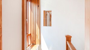 Un pasillo estrecho con paredes de madera y una ventana pequeña.