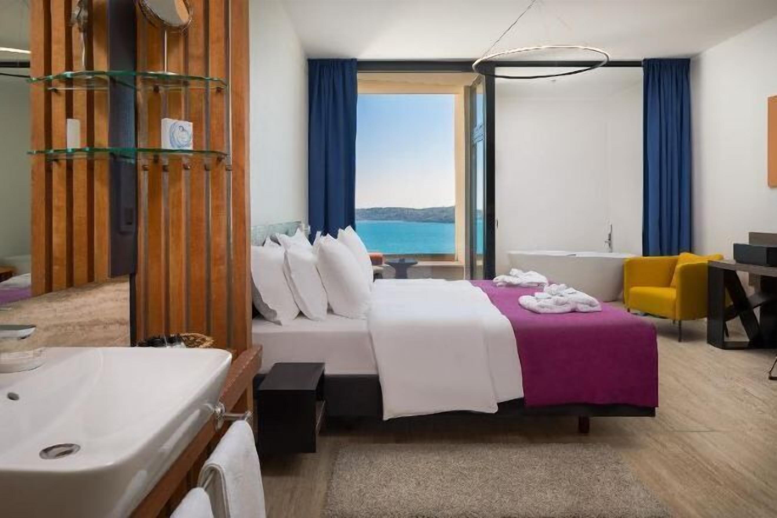 Sengetøy av topp kvalitet, dundyner, minibar og safe på rommet
