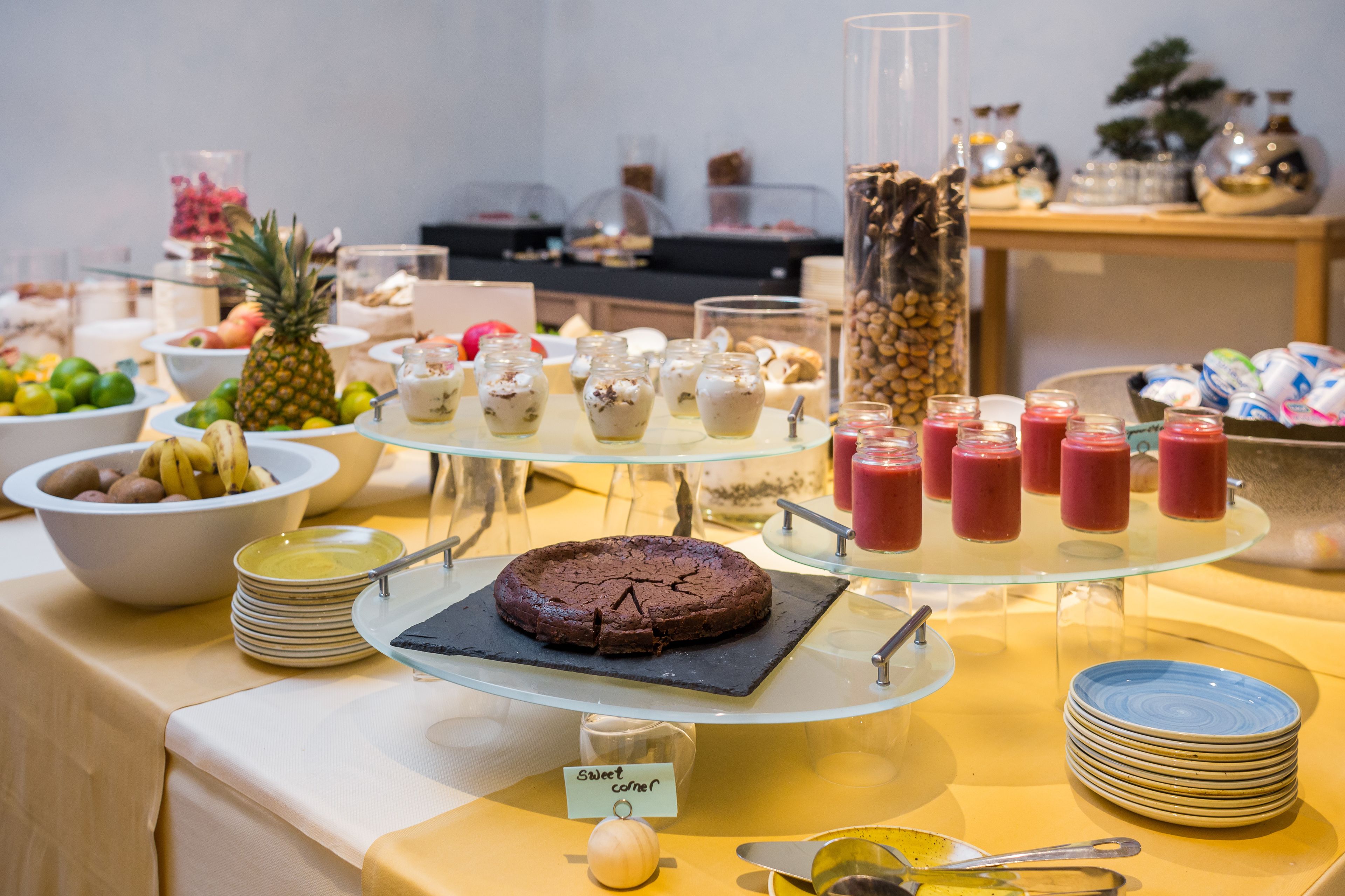 Un bufé con diversas opciones de comida, incluyendo un pastel, fruta y bebidas.