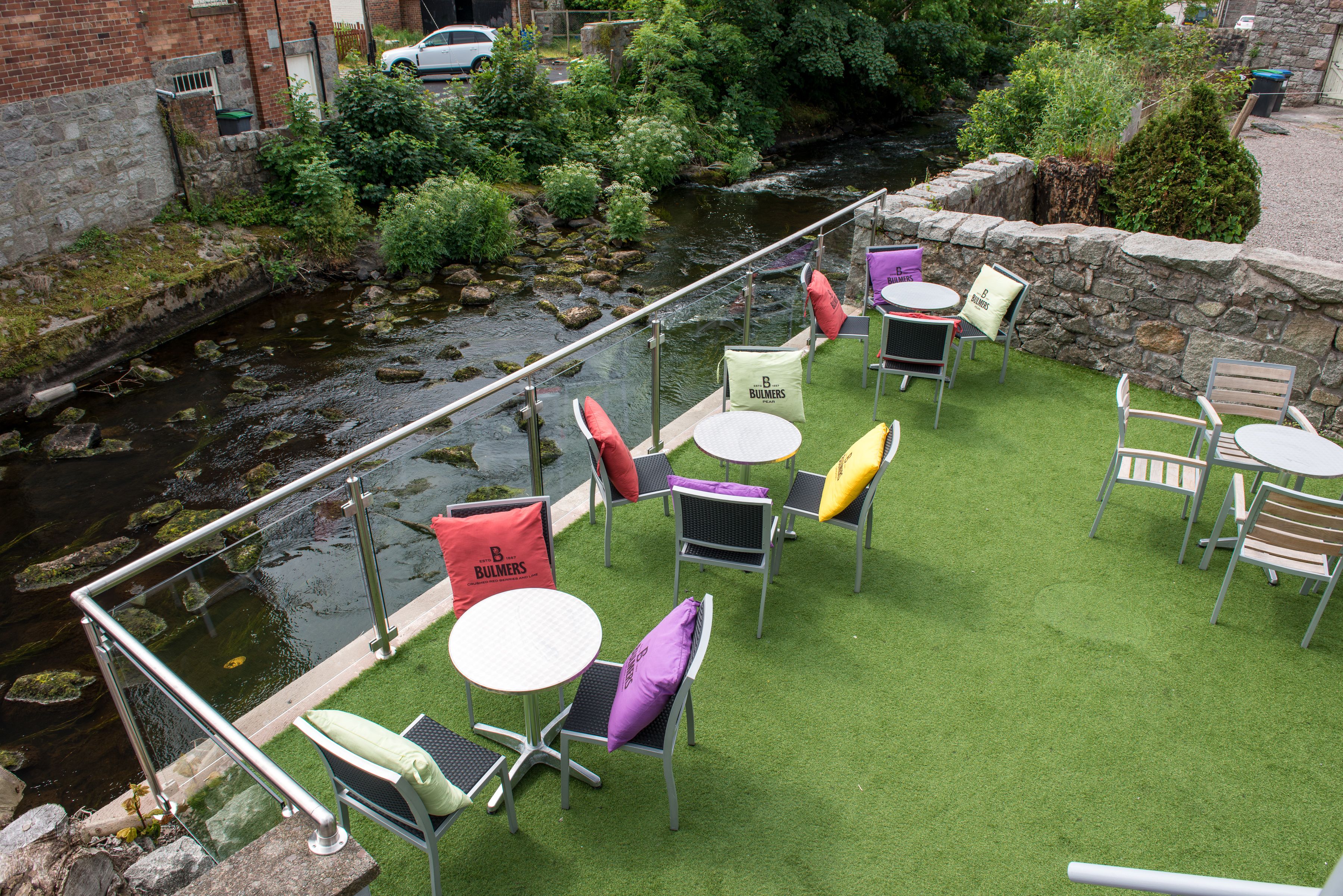 Eine Terrasse mit Sitzgelegenheiten und Blick auf einen Fluss.