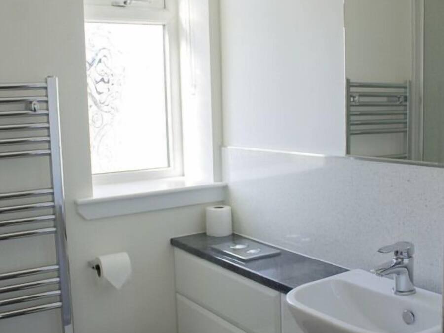 A small, clean bathroom with a toilet, sink, and window.