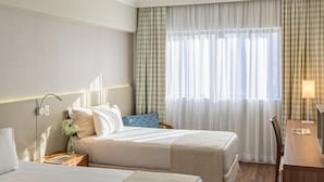 A hotel room with two beds, a desk, and a chair. - Mendes Plaza Hotel Torre Panorama (Santos)