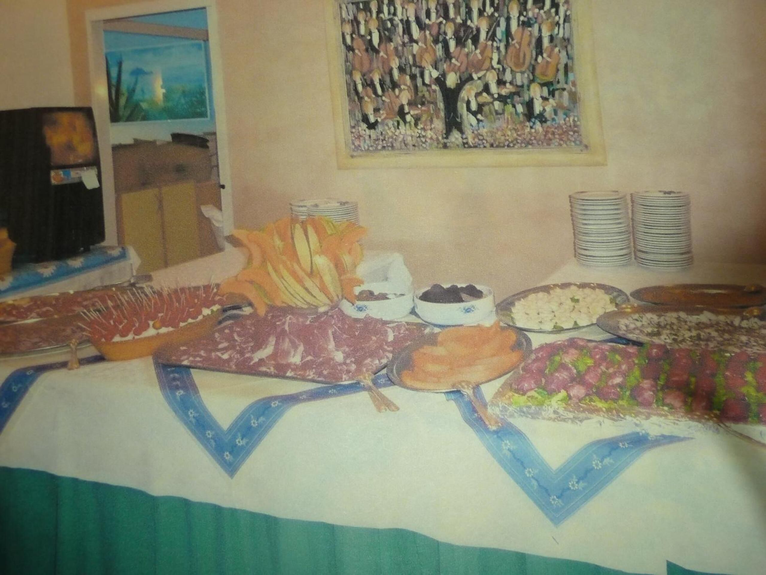 A buffet table with various food items and a painting on the wall.