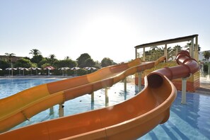 Parque acuático con múltiples toboganes sobre una piscina.