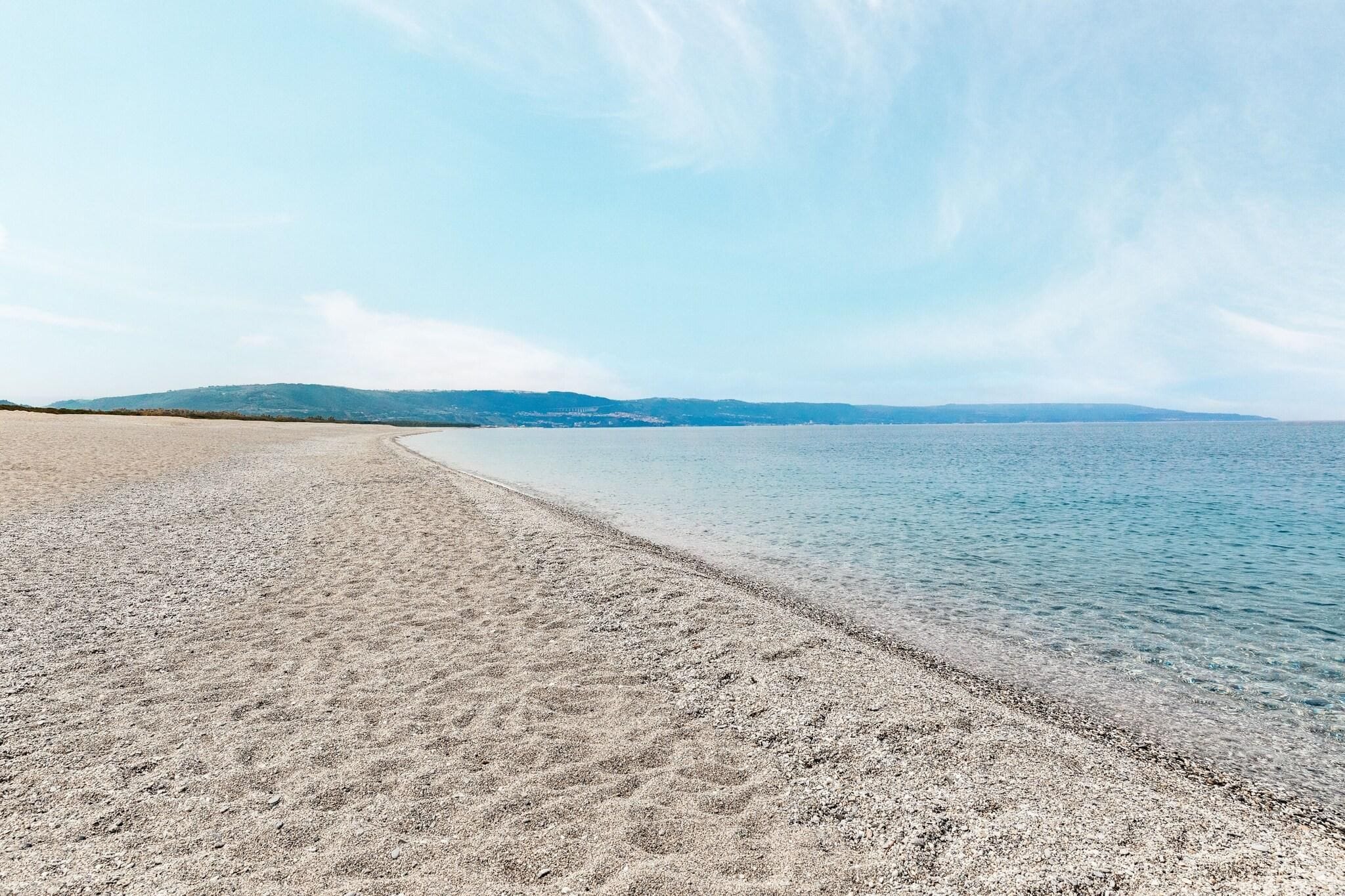 A beach with a clear sky and calm water.