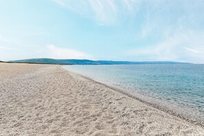 Una playa con cielo despejado y agua tranquila.