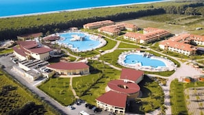 Un complexe hôtelier doté de plusieurs piscines, de villas pour les clients et offrant une vue sur la mer.