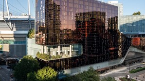 A modern building with a glass facade, a curved structure, and a bridge-like feature extending from the main building. - the DOUGLAS, Autograph Collection (Vancouver)