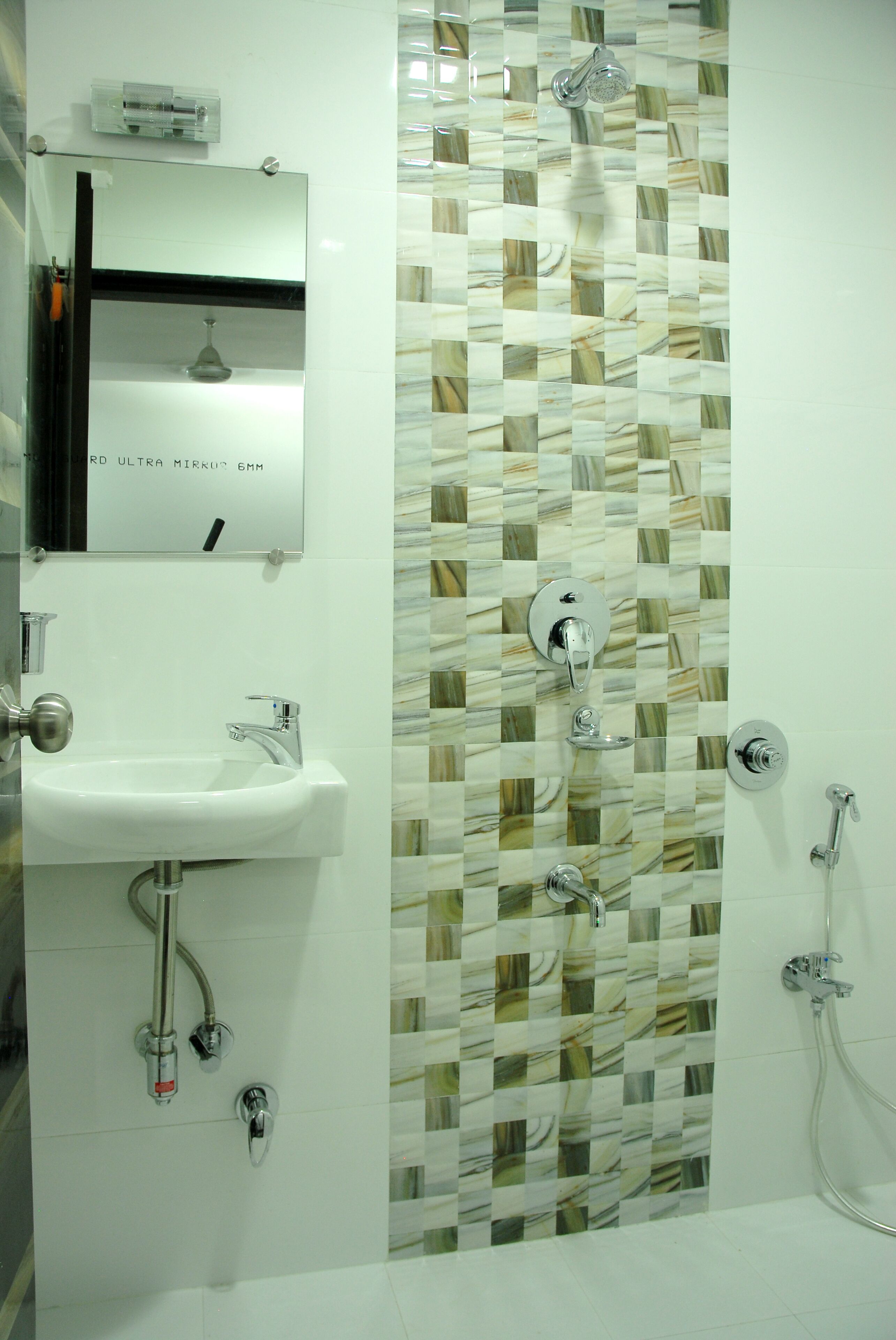 A bathroom with a sink, mirror, and shower.