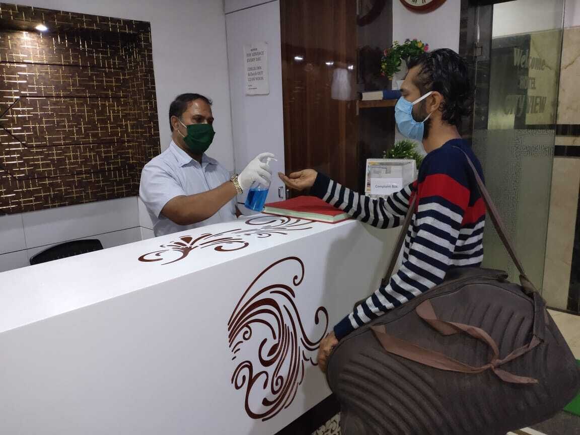 A reception desk with a white surface and decorative swirls. A person is handing over a document to a receptionist.