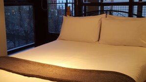 A hotel room with a large bed, a view of the city through the windows, and a balcony with a railing. - MetroStays - Temple Bar 5 (Dublin)