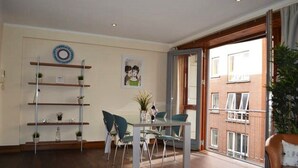 A modern living room with a dining area, featuring a glass table, metal chairs, and a bookshelf. - MetroStays - Temple Bar 18 (Dublin)