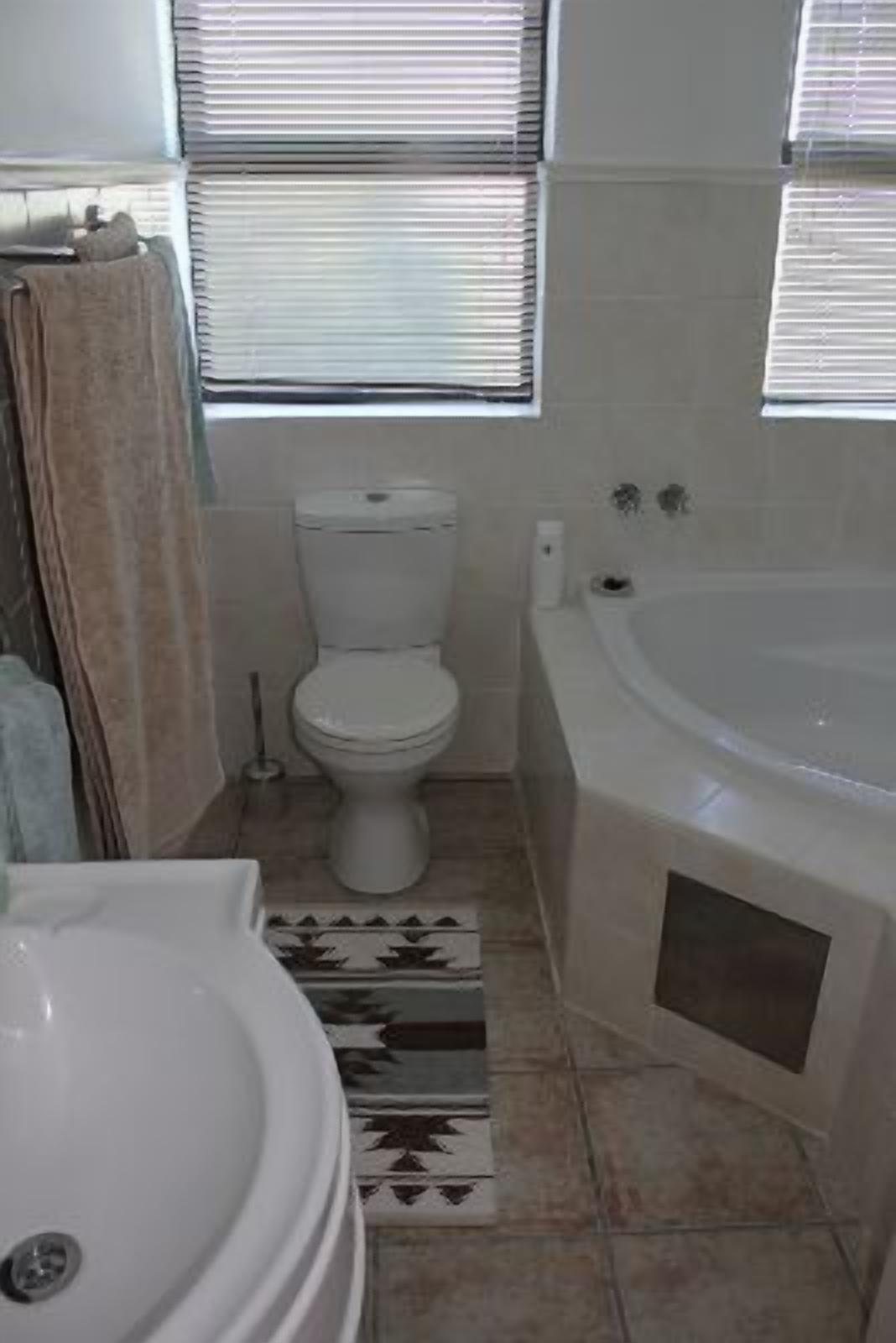 A bathroom with a toilet, bathtub, and sink.