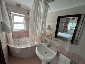 A bathroom with a bathtub, a sink, a mirror, and a window. - Paraiso del Mar (Nerja)