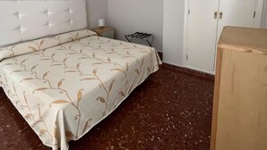 A bedroom with a bed, a nightstand, a lamp, a wardrobe, and a painting on the wall. - Paraiso del Mar (Nerja)