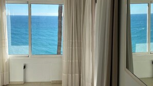 A room with a large window overlooking the sea, white curtains, and a large mirror. - Paraiso del Mar (Nerja)