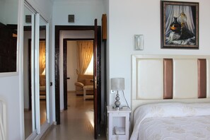 A hotel room with a bed, bedside table, lamp, and a painting on the wall. - Paraiso del Mar (Nerja)