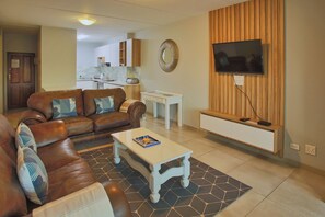 Departamento Confort, 2 habitaciones | Área de sala de estar | Televisión 