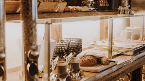 A buffet setup with various food items and serving utensils. - B&B Hotel Die Bergquelle (Flachau)