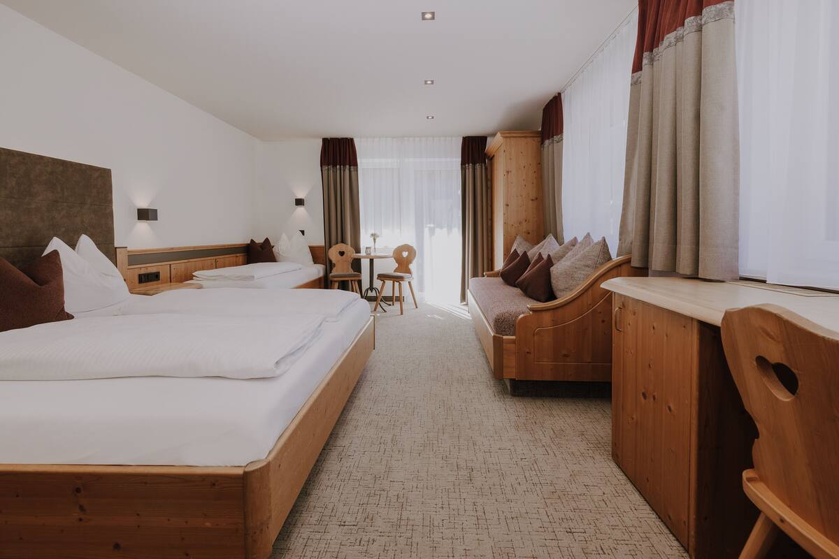 Ein Hotelzimmer mit zwei Betten, einem Holztisch, einem kleinen Tisch und einem Stuhl.