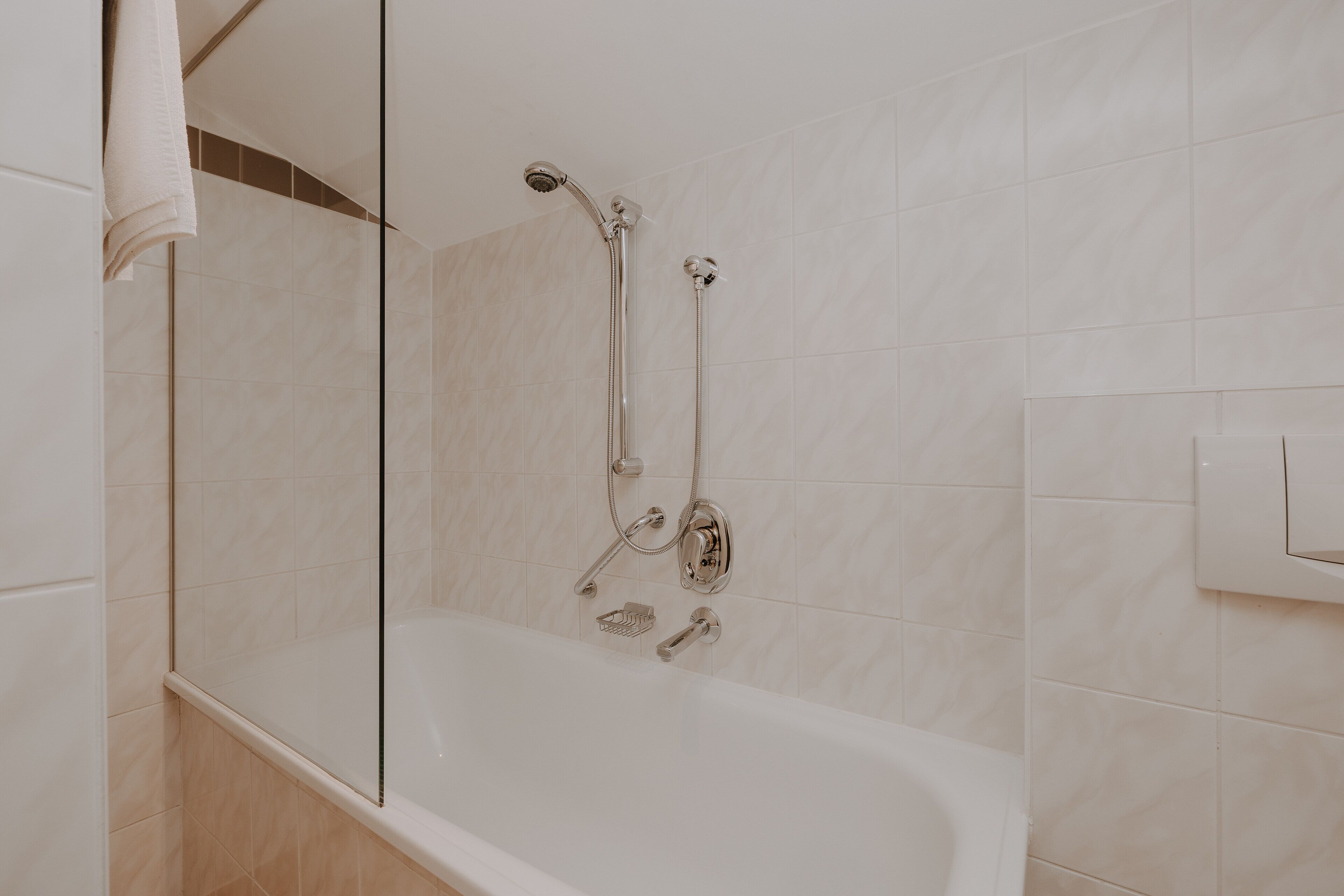 A modern bathroom with a bathtub, shower, and glass-enclosed shower area.