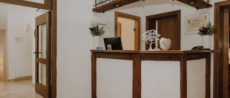 A reception desk with a wooden frame, a computer, and decorative items.