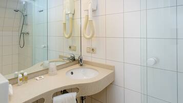A bathroom with a sink, mirror, and towel rack.
