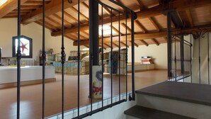 Une pièce mansardée spacieuse avec un plafond en bois, un escalier et une vue sur l’espace de vie situé en contrebas.