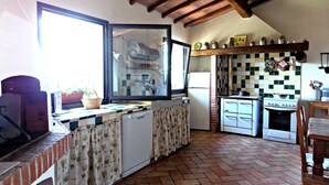 Une cuisine de taille réduite, dotée d’une fenêtre, d’un réfrigérateur, d’une cuisinière et d’un évier.