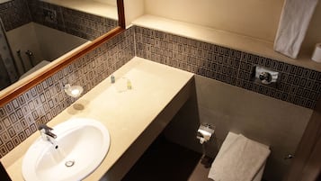 Un bagno con lavandino, specchio e doccia.