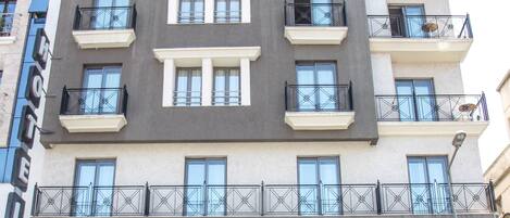 Un edificio de varios pisos con un restaurante en la planta baja llamado 'Mister Ice' y 'Mister Pizza'.