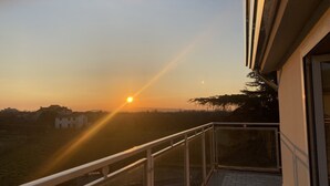 A balcony with a view of the sunset over a residential area. - Victoria Hotel (Castello di Cisterna)