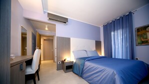 A modern hotel room with a bed, bedside table, chair, and a desk. - Victoria Hotel (Castello di Cisterna)