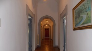 A hallway with a tiled floor, arched doorways, and a ceiling fan. - Villa Senni (Scarperia e San Piero)