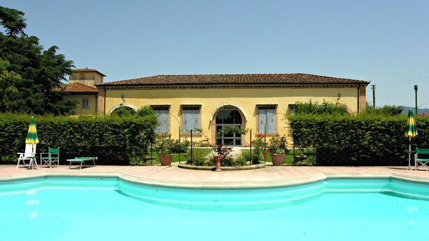 A pool with a tiled deck, a building with arched windows, and a well-maintained garden. - Villa Senni (Scarperia e San Piero)
