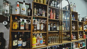 A liquor store with shelves stocked with various bottles of alcohol, including whiskey, vodka, and gin. - Denville Hotel (Blackpool)