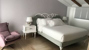 Une chambre à coucher avec un lit, des tables de chevet, une lampe et une chaise.