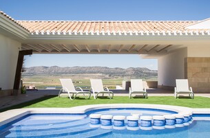 Una piscina al aire libre de temporada, sombrillas