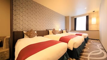 A hotel room with three beds, a patterned wall, a large window, and a carpeted floor.