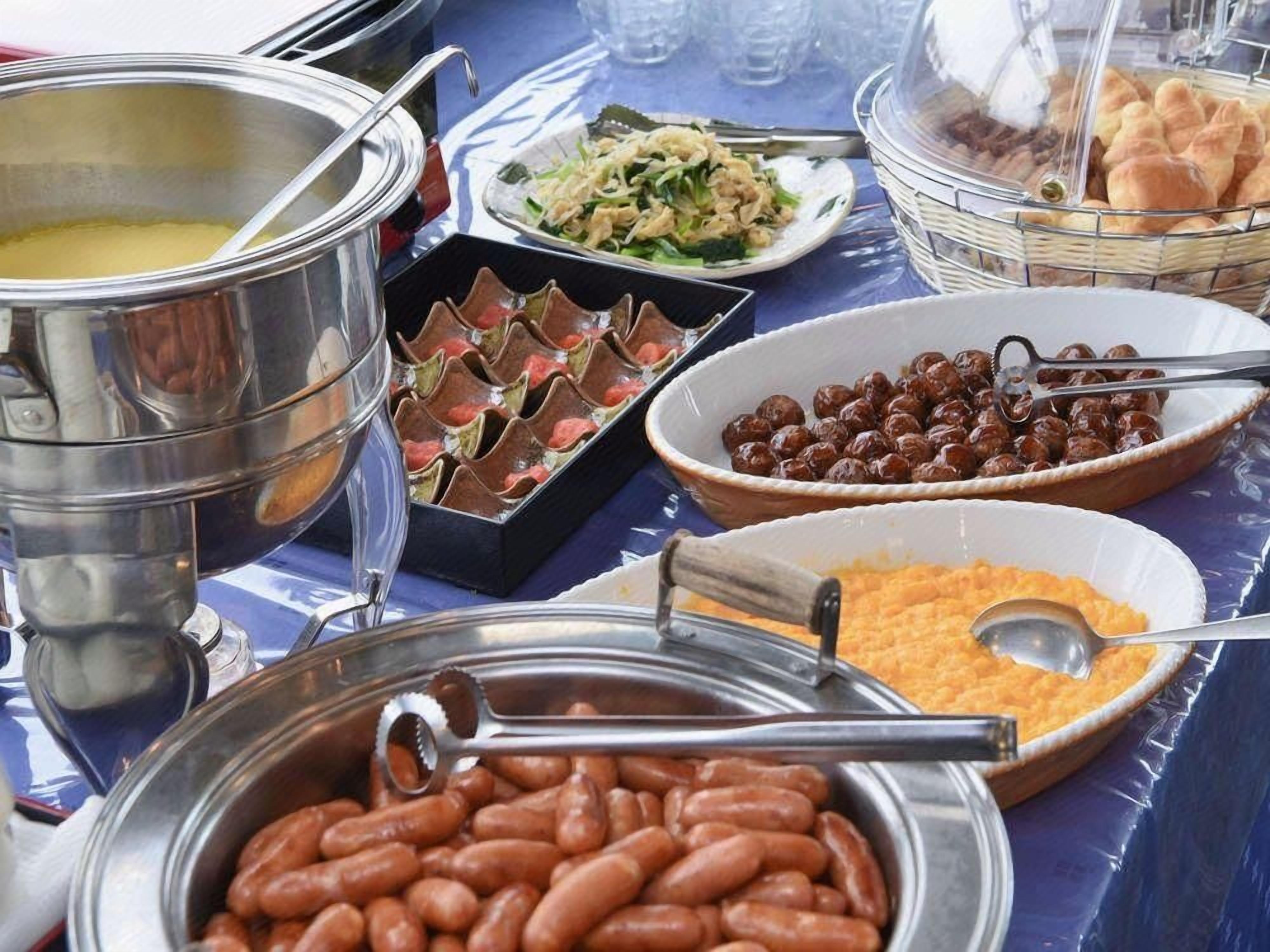 Una mesa de buffet con diversos alimentos, como frijoles, ensaladas y pan.